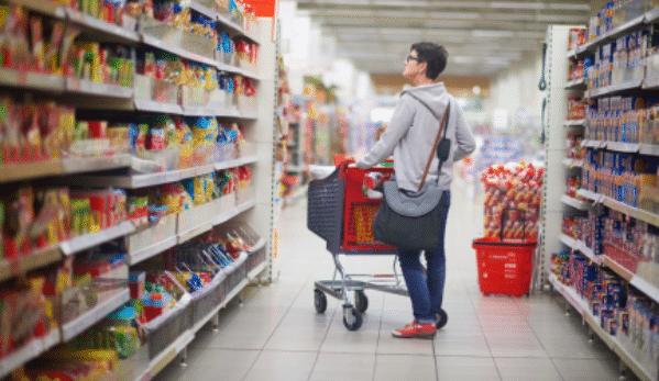 Woman in supermarket looking at HFSS foods